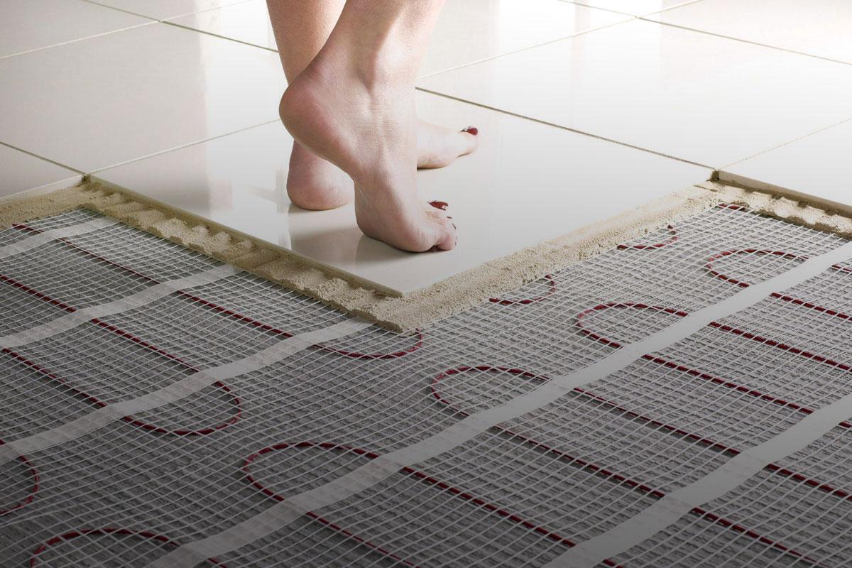 Feet stepping onto a heated floor in a tiled kitchen