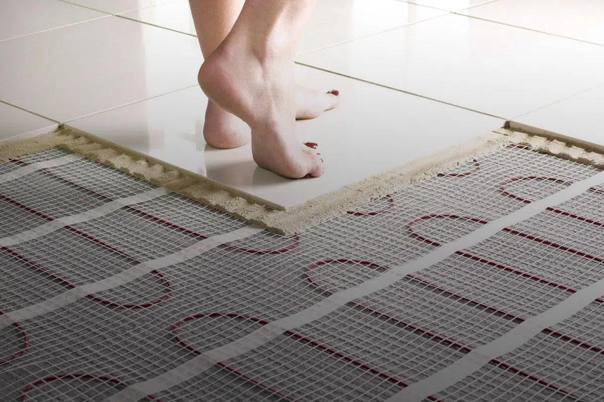 Feet stepping onto a heated floor in a tiled kitchen